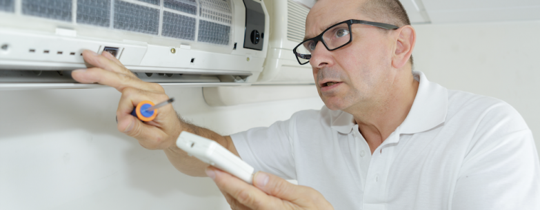 A home owner giving his air conditioner some maintenance.