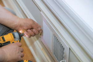 Installation of a ducted air-conditioning system using a drill.