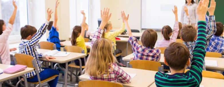 Students raising their hands in class.