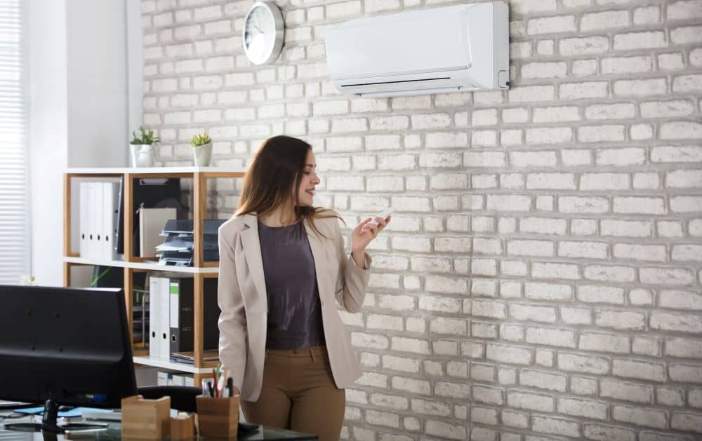 Employee turning AC on using remote control.