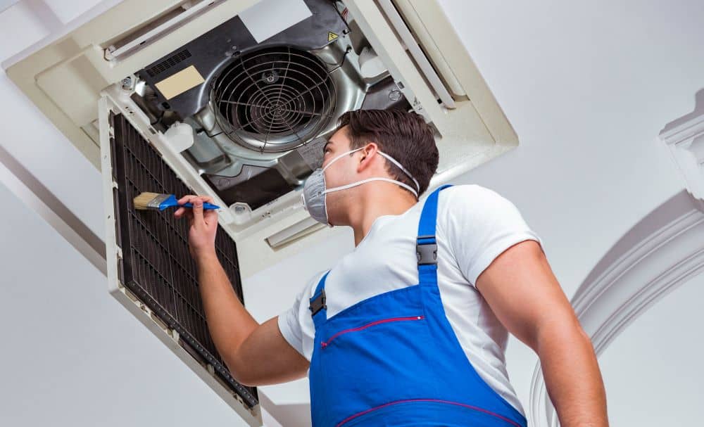 Worker cleaning air conditioner filter.