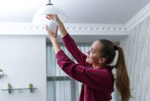 Woman replacing LED bulb.