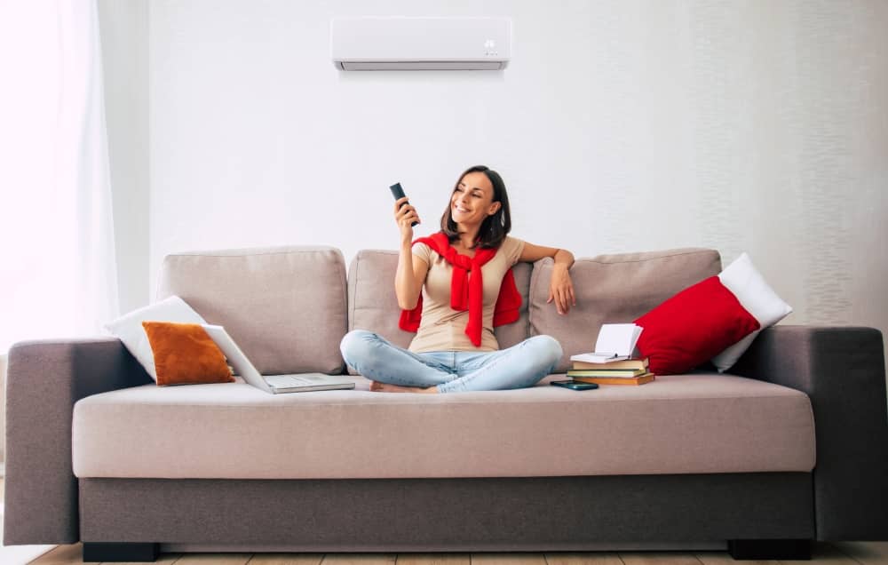 Woman using air conditioner at home.